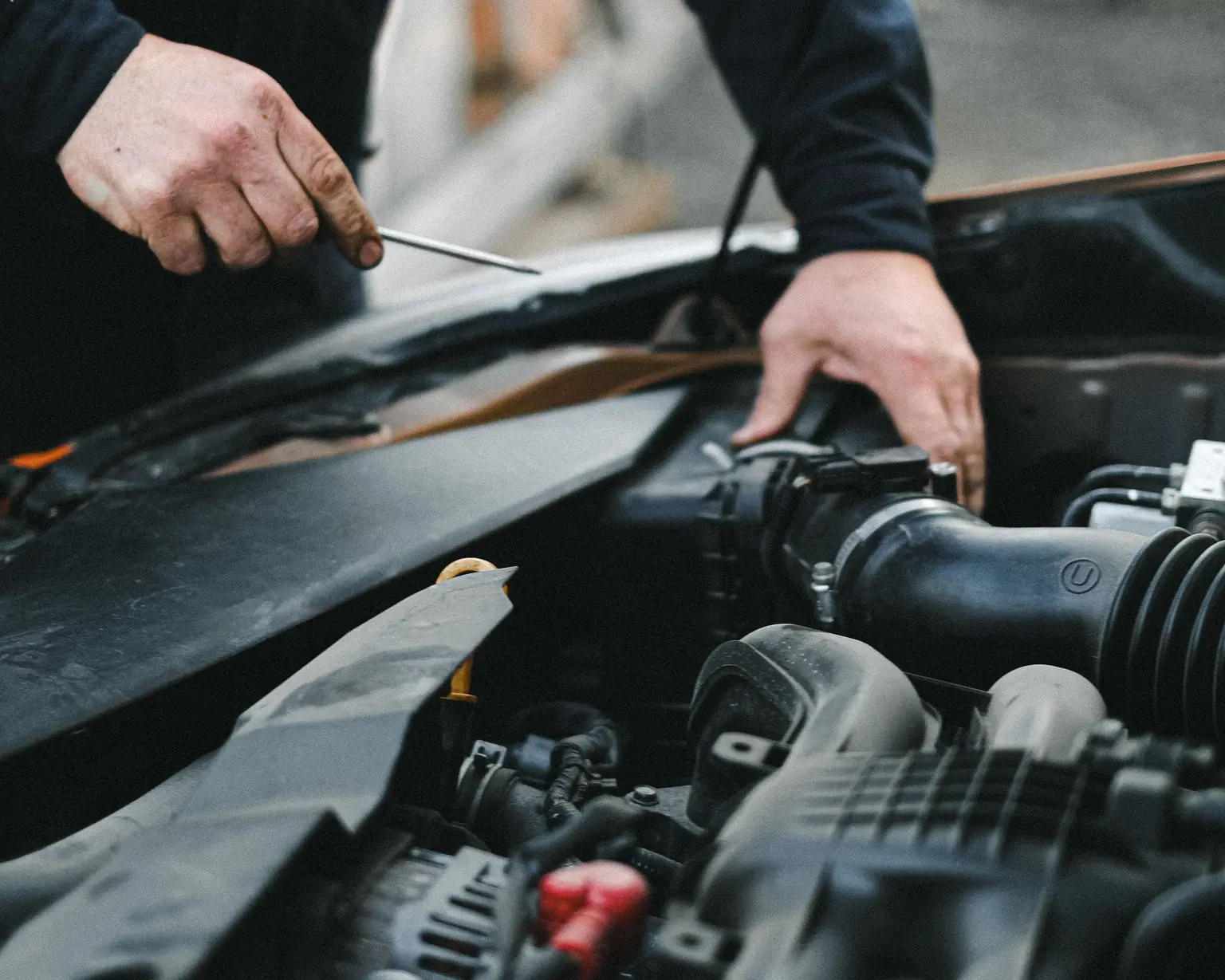 Mechanic’s hands working under an open bonnet