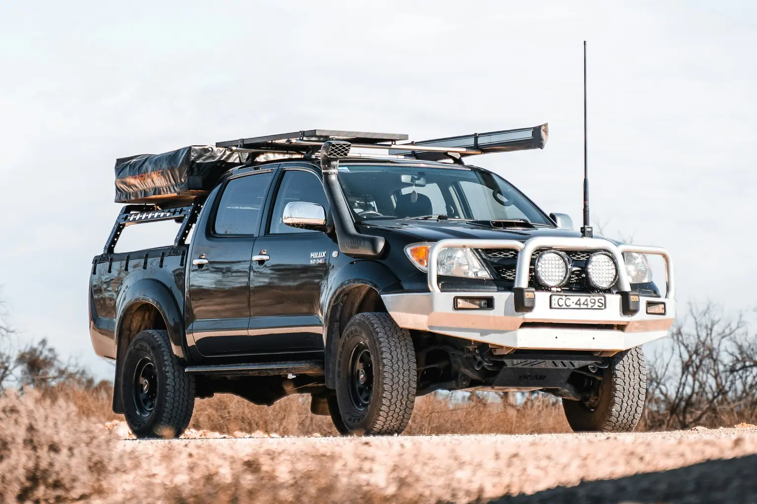 Toyota Hilux ute viewed from the front three-quarter angle on a dirt track
